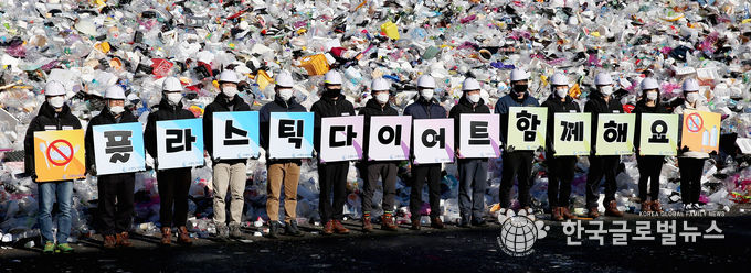 19일 오전 수원시자원순환센터 플라스틱 야외적치장에서 수원도시공사 임직원들이 ‘고고 릴레이’ 캠페인의 일환으로 ‘플라스틱 다이어트 함께해요’란 글이 새겨진 피켓을 선보이는 퍼포먼스를 하고 있다. (사진=수원도시공사 제공)<br>
<br>
