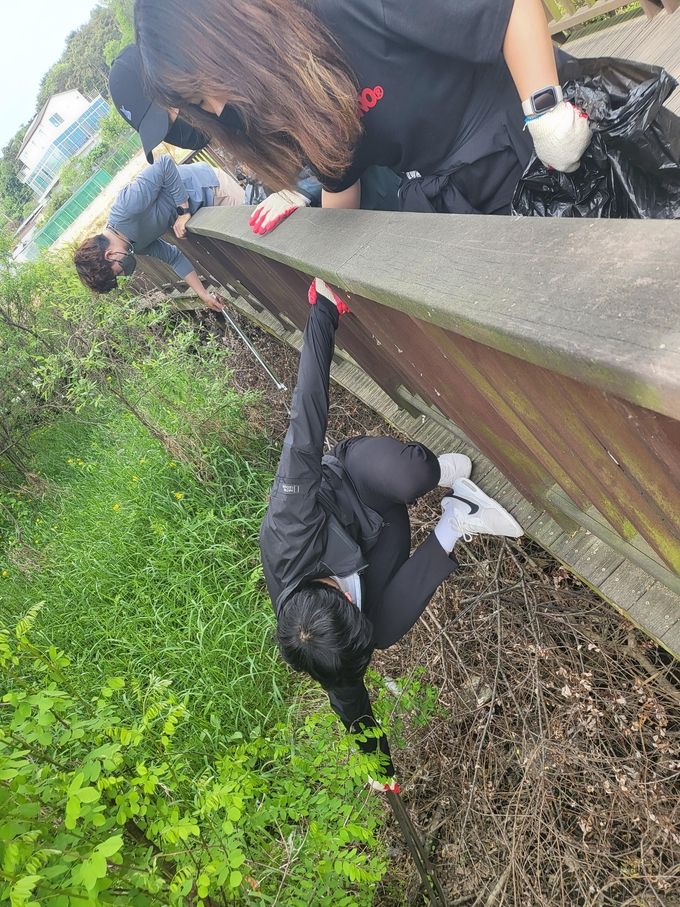 데코 밑 떨어져있는 쓰레기를 위험도 마다 않고 줍고 있는 환실련 회원.