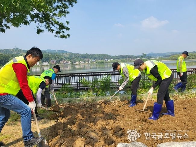 저수지 주변 공터를 꽃밭으로 조성하기 위한 터파기에 열중인 회원들