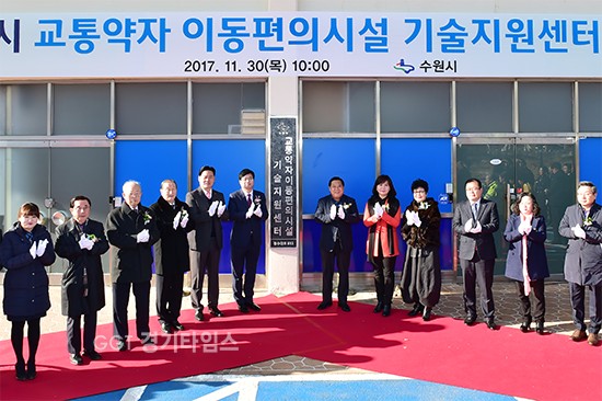 염태영 수원시장(현판 왼쪽)과 김진관 수원시의회 의장(현판 오른쪽), 관계자들이 ‘수원시 교통약자 이동편의시설 기술지원센터’ 현판 앞에서 기념 촬영을 하고 있다.ⓒ경기타임스