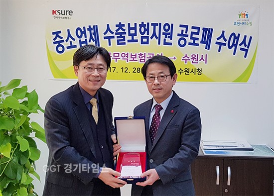 이택용 수원시 일자리경제국장(오른쪽)과 한국무역보험공사 관계자가 공로패를 들고 기념 촬영을 하고 있다.ⓒ경기타임스