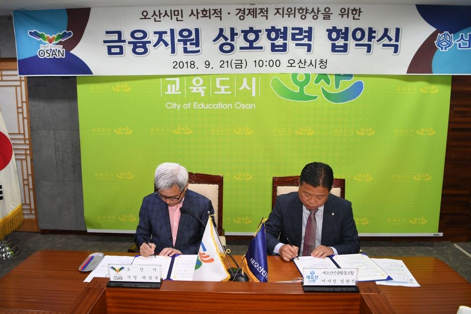 곽상욱 오산시장과 임완식 새오산신협 이사장이 협약서에 서명을 하고 있다.
