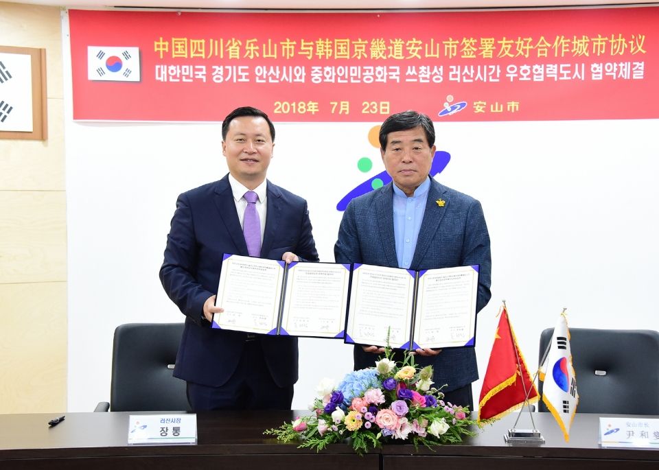 윤화섭 안산시장(오른쪽)이 7월 23일 시청 제1회의실에서 ‘안산시와 중국 쓰촨성 러산시 간 우호협력도시 관계수립 협약’을 체결하고 장통 러산시장과 함께 기념 촬영을 하고 있다.