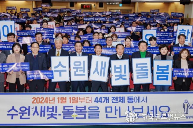 지난해 12월 수원시 관계자들이 수원새빛돌봄 전체 동 확대를 홍보하는 손팻말을 들어 보이고 있다.