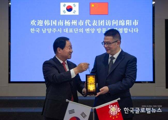 주광덕 남양주시장(좌)이 리원 몐양시장(우)에게 기념품을 전달하고 있다.