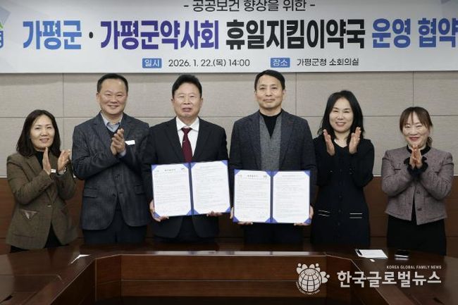 서태원 가평군수(사진 왼쪽에서 세번째)와 안병현 가평군약사회 회장(〃 네번째) 등이 22일 휴일지킴이약국 운영 협약식 후 협약서를 보이며 기념촬영을 하고 있다.